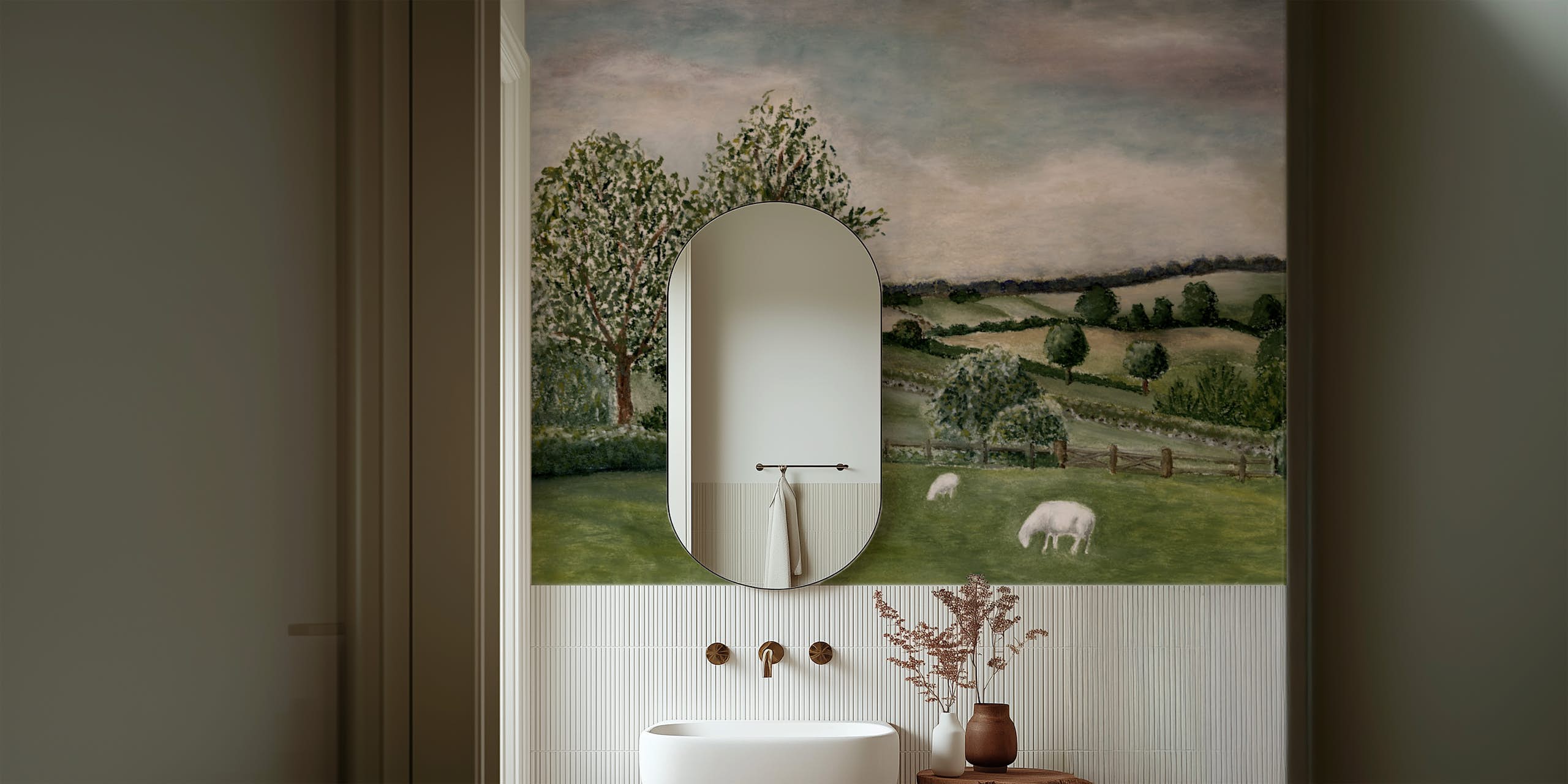 landscape-mural-wallpaper-powder-room-fluted-tile Landscape mural wallpaper with grazing sheep above fluted white tile in a powder room with an oval mirror and brass fittings.